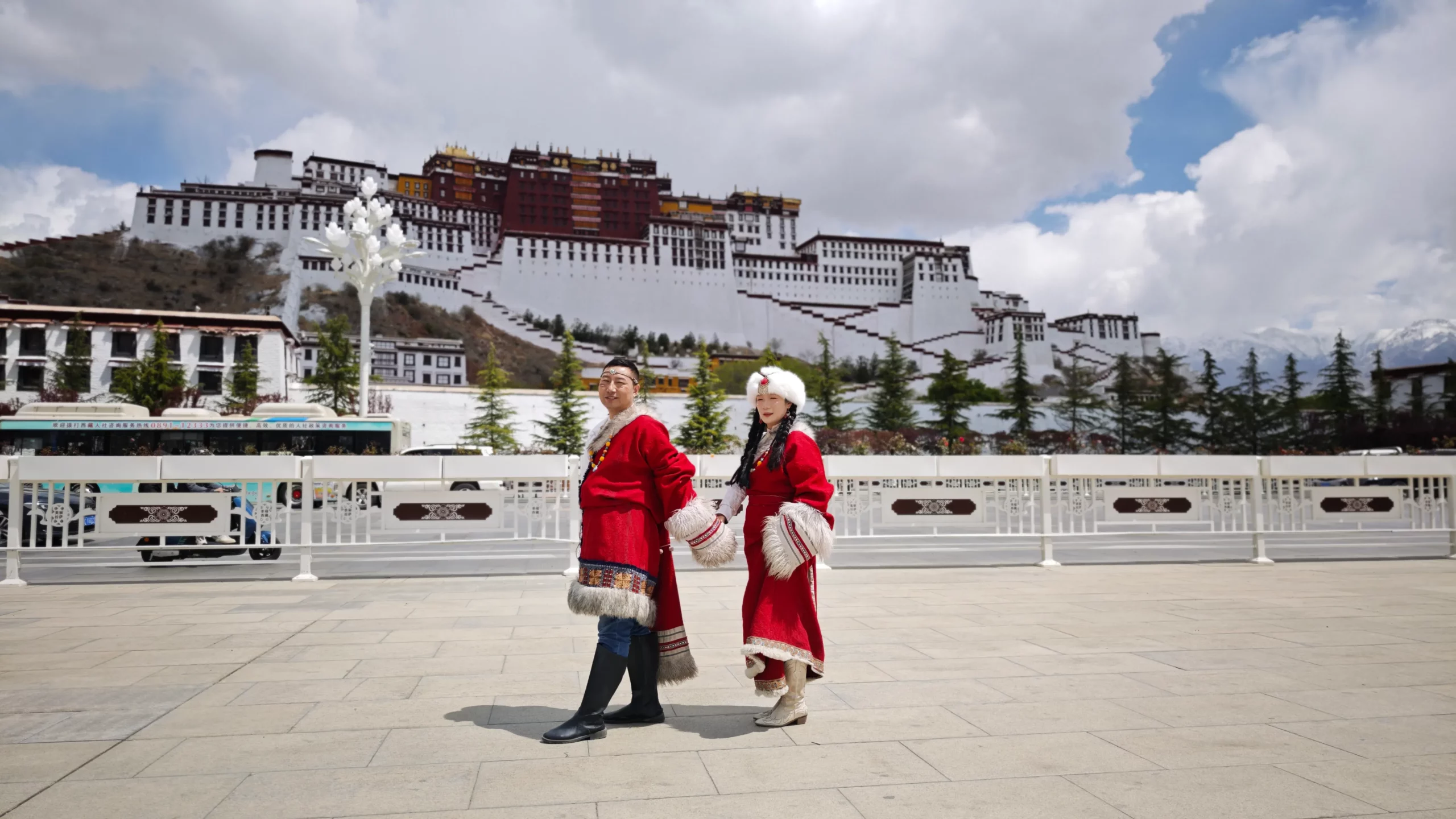 Chinese couple in traditional attire at Potala Palace square.