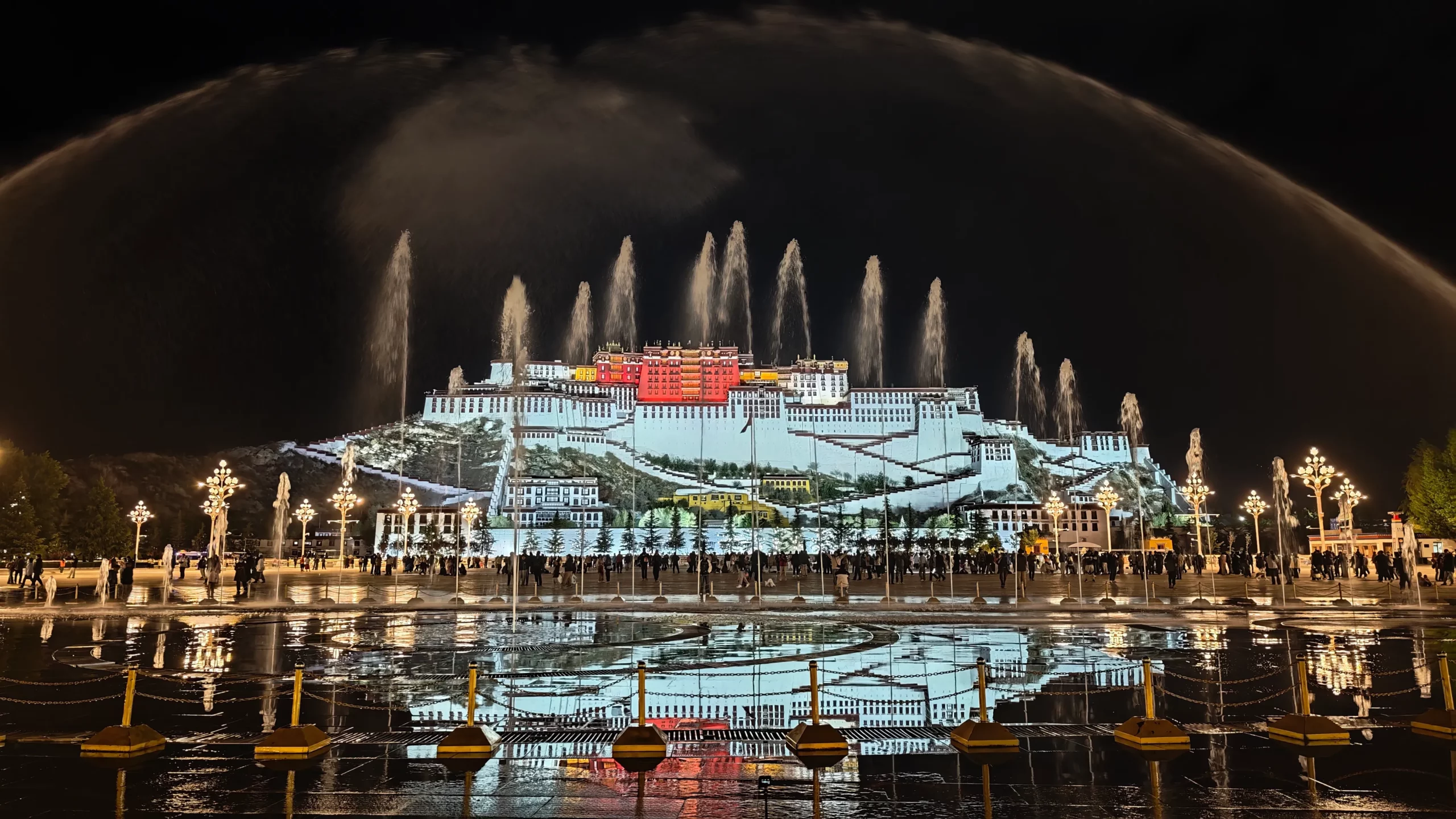 Light and water show in front of the Potala Palace at night.