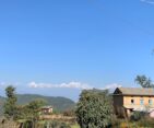 An image featuring the mountains as seen from Nagarkot, complemented by the presence of a traditional local house, highlighting the cultural and natural blend of the region.