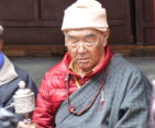 Old Sherpa Monk praying in the monastery.