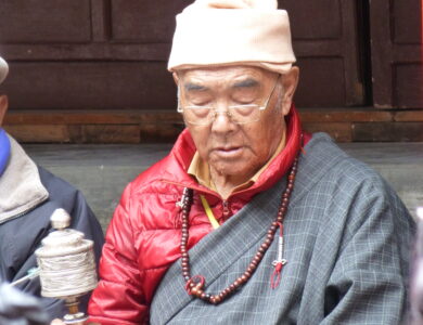 Old Sherpa Monk praying in the monastery.