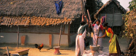Tharu women engaged in daily work activities, reflecting the industrious and communal lifestyle of the Tharu people.