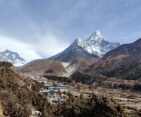 A stunning view of Ama Dablam Mountain towering over the quaint Pangboche Village in the Everest region.