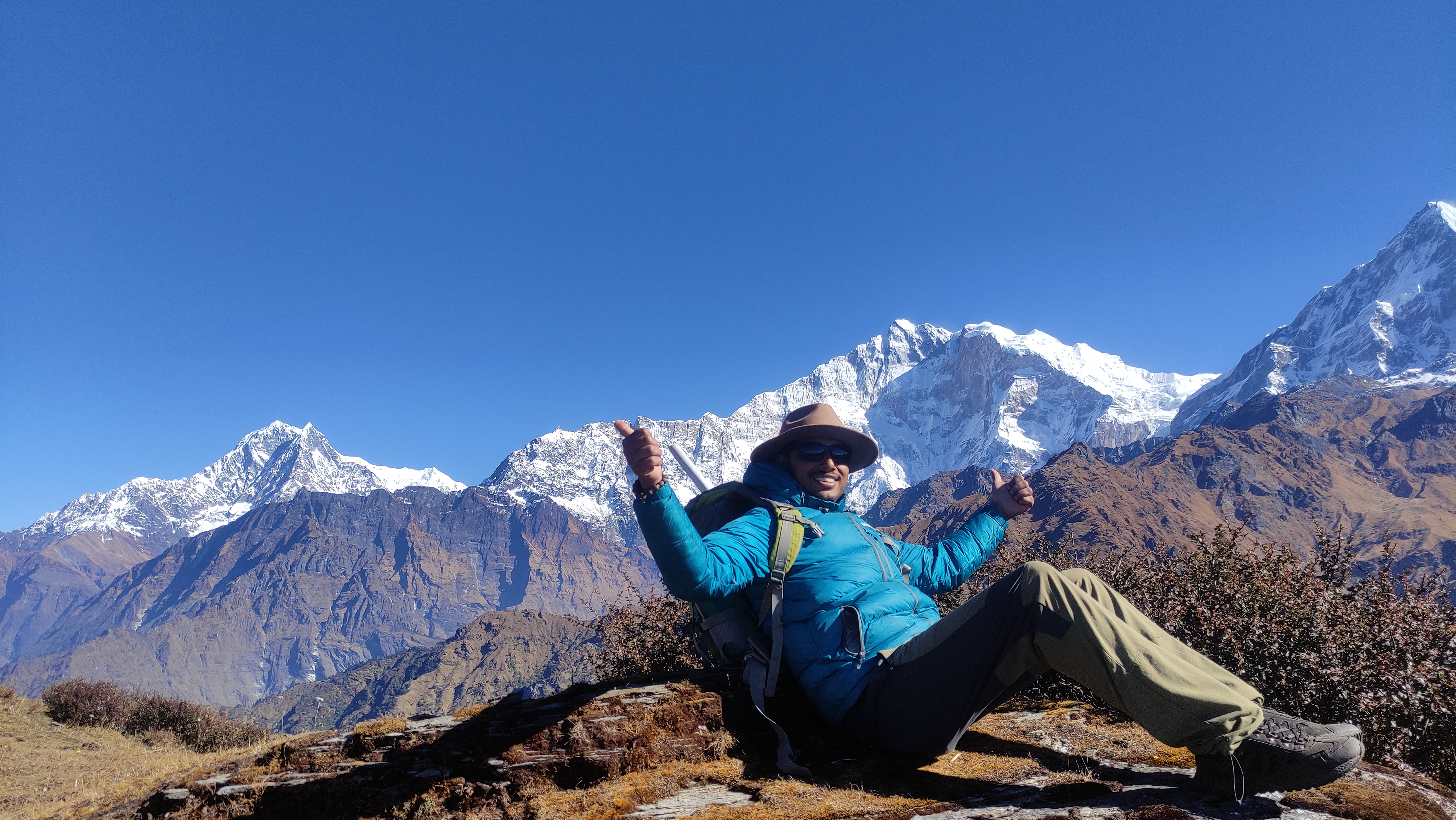 Founder Mr. Rajan playfully posing a question amidst breathtaking mountain views, blending humor with appreciation for nature.