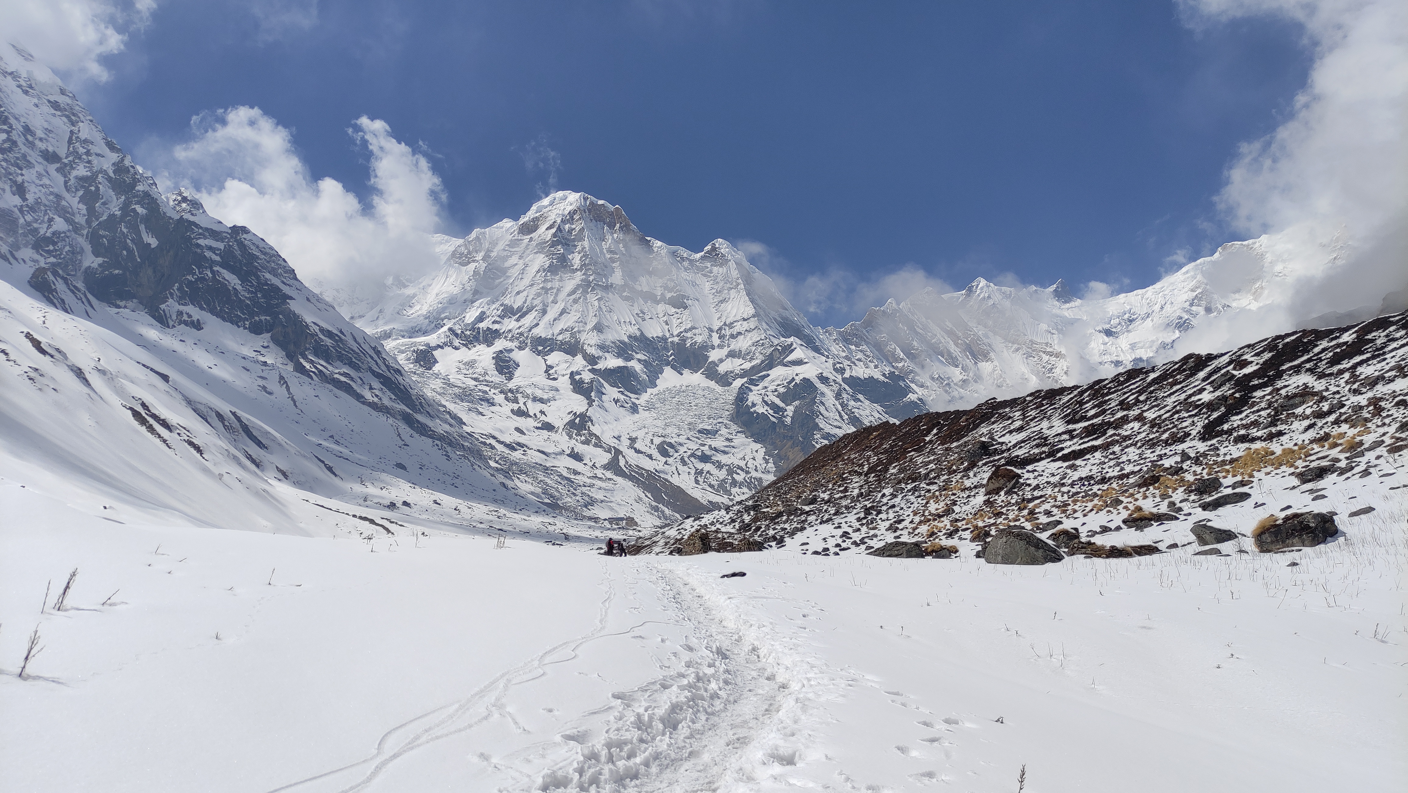 Snow-covered trail leading to Annapurna Base Camp, surrounded by majestic peaks and pristine wilderness.