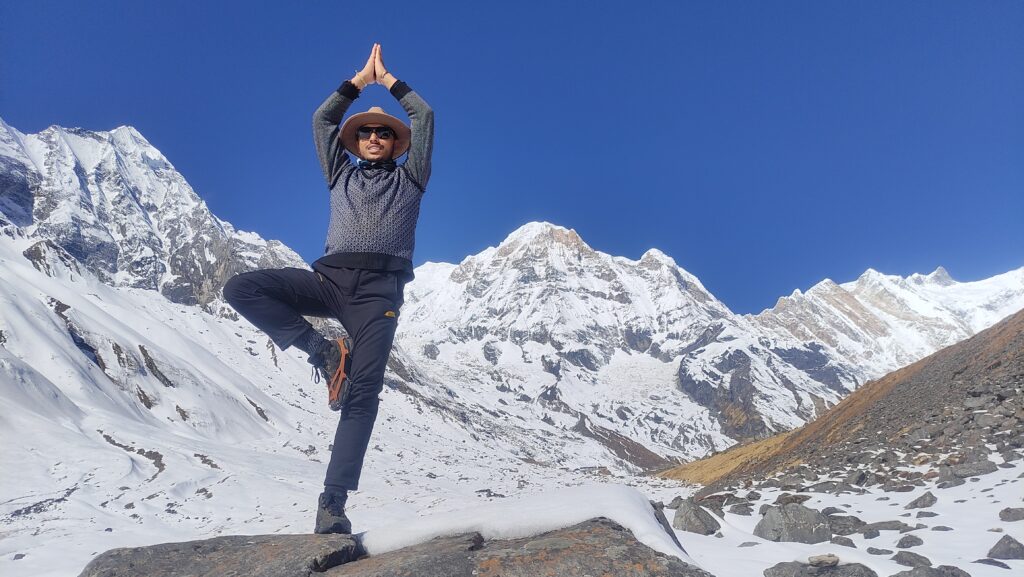 Practicing Surya Namaskar (Sun Salutation) at Annapurna Base Camp, blending yoga with breathtaking Himalayan scenery.