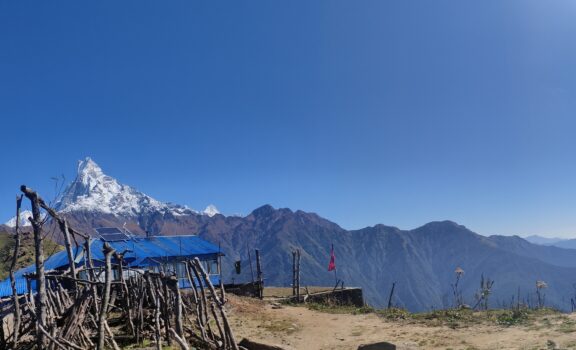 Panoramic view of the Annapurna mountain range, showcasing its grandeur and rugged beauty under a clear blue sky.