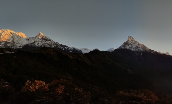 anoramic view of the massive Annapurna mountain range during a breathtaking sunrise, painting the sky and peaks with vibrant colors.