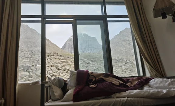 Traveler resting in their room in Derapuck with view of Mount Kailash from the window.