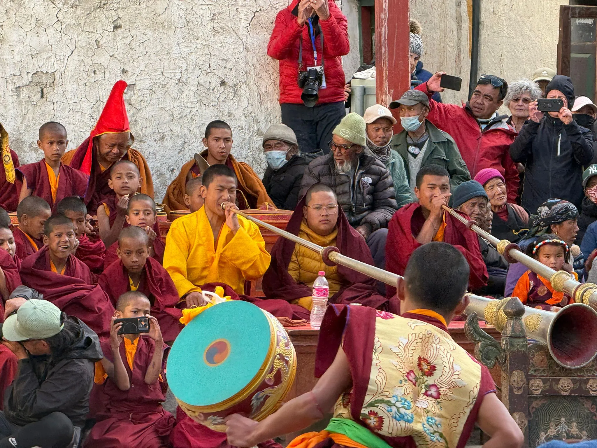 Buddhist monks performing traditional rituals and playing ceremonial instruments during the vibrant Tiji Festival celebration in Upper Mustang, Nepal.