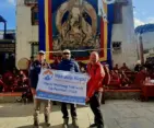 Upper Mustang Trek with Tiji Festival 2026 group holding company banner during cultural tour in Lo Manthang, Nepal