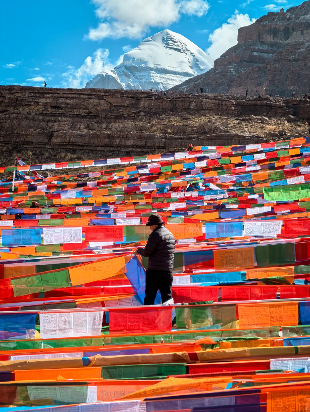 A devotee offering prayer flags during the Kailash Saga Dawa Festival Tour.