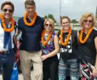 Happy international family group welcomed to Nepal with traditional marigold garlands during their Family Tour in Nepal 2026, standing together after arrival.