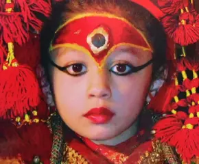 Living Goddess Kumari of Nepal in traditional red attire and ceremonial makeup during a cultural festival in Kathmandu