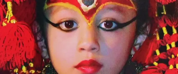 Living Goddess Kumari of Nepal in traditional red attire and ceremonial makeup during a cultural festival in Kathmandu