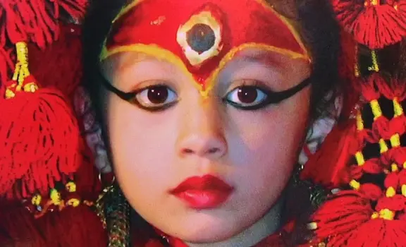 Living Goddess Kumari of Nepal in traditional red attire and ceremonial makeup during a cultural festival in Kathmandu