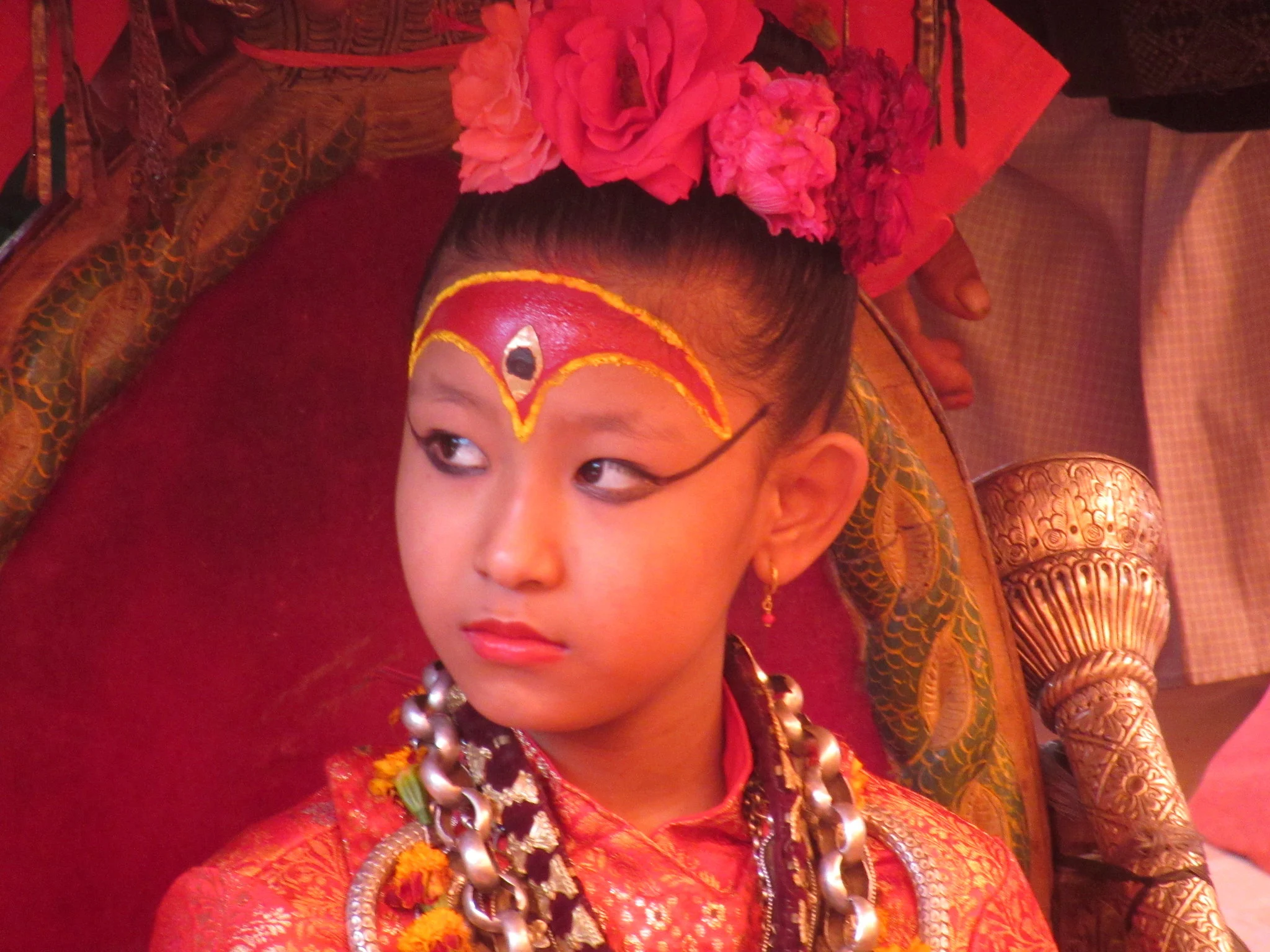 Living Goddess Kumari of Nepal in traditional red attire and ceremonial makeup during a cultural festival in Kathmandu