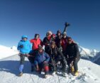 Climbing team celebrating on the summit of Mera Peak with snow-covered Himalayan peaks in Nepal
