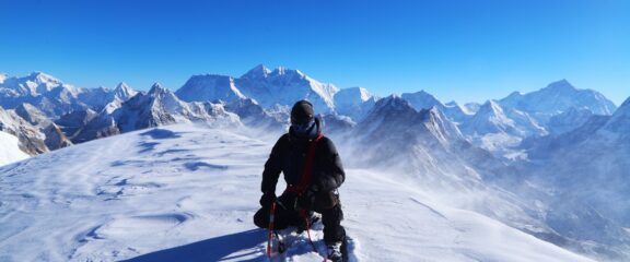 Our experienced guide on the summit of Mera Peak with Mount Everest and surrounding peaks.